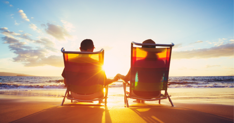 Couple watching sunset on beach chairs